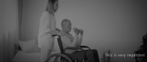 a woman rubbing the shoulders of a man in a wheelchair