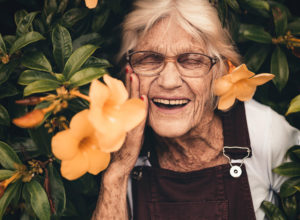 Older woman smiling with flowers