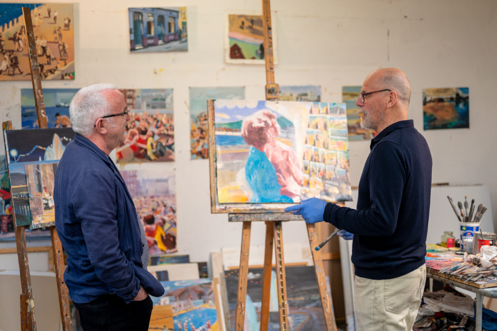 a painter showing his painting to another man
